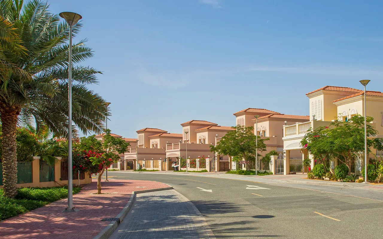 Completed Jumeirah Village Triangle villas beside a tree-lined residential street. Area context, not a photograph of Binghatti Flare 01.