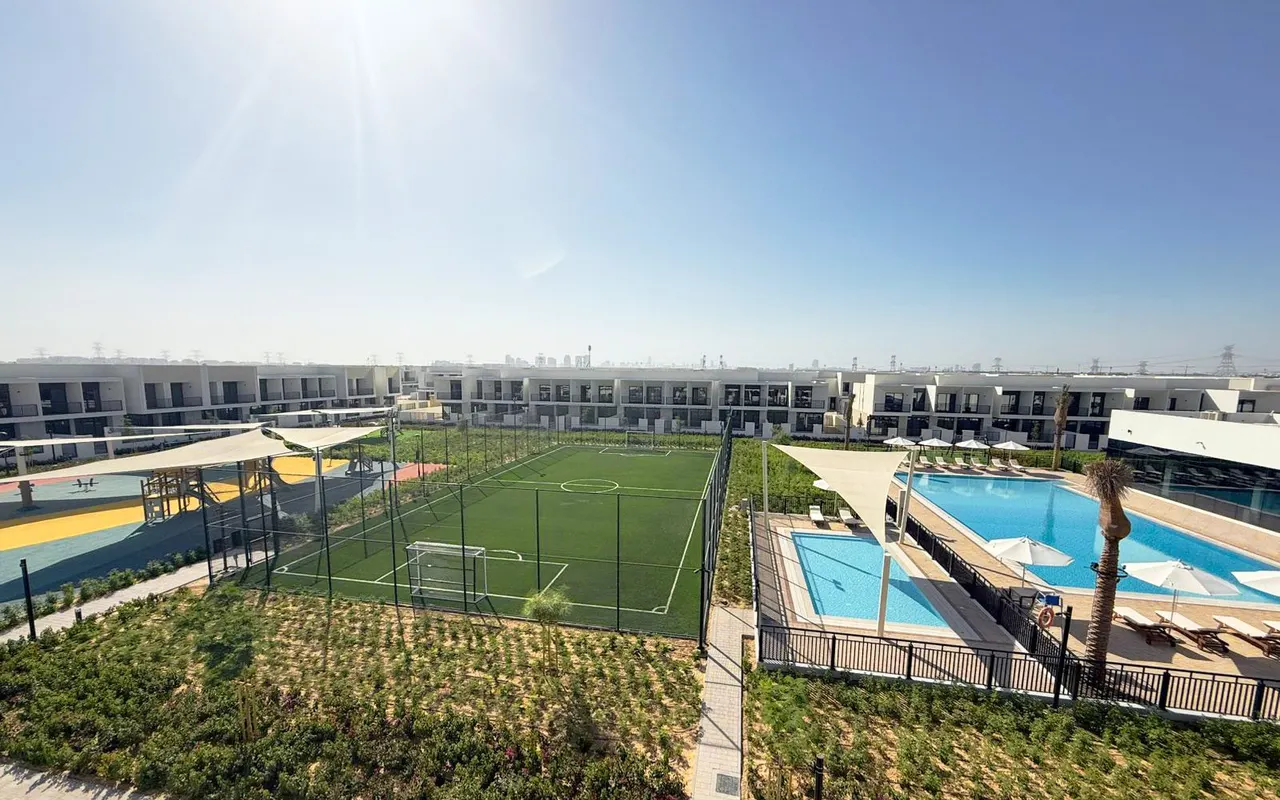Maha Townhouses sports courts, swimming pool and completed homes within Town Square. Area context, not a photograph of Grove on the Park.