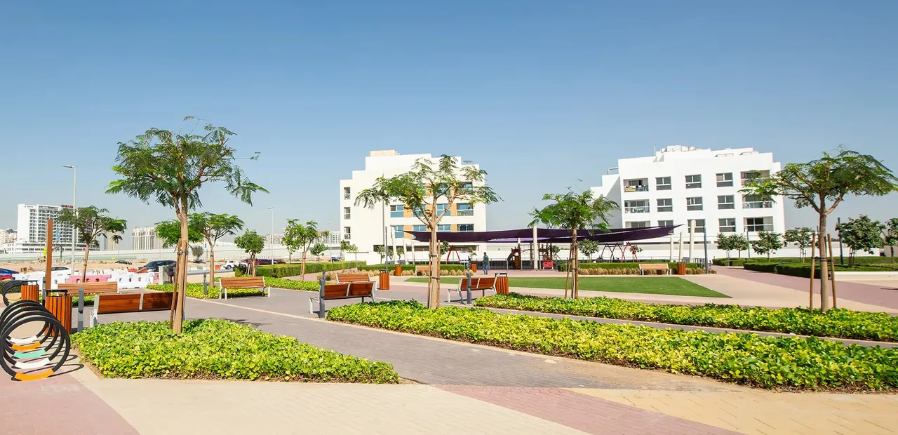 Completed residences and landscaped playground in Dubai Land Residence Complex. Area context, not a photograph of Forest City Tower 2.