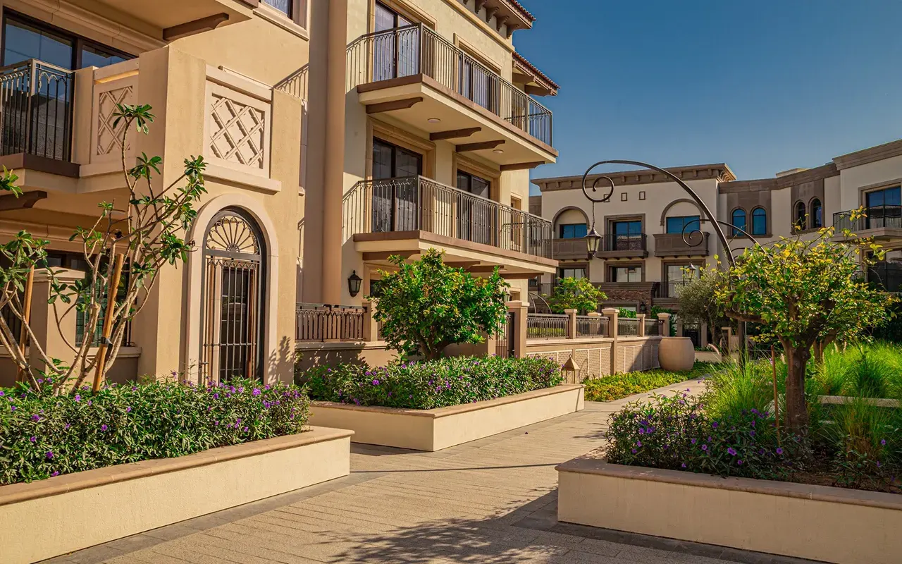 Completed residential facades and landscaped courtyard in Madinat Badr. Area context, not a photograph of Qamar 7.