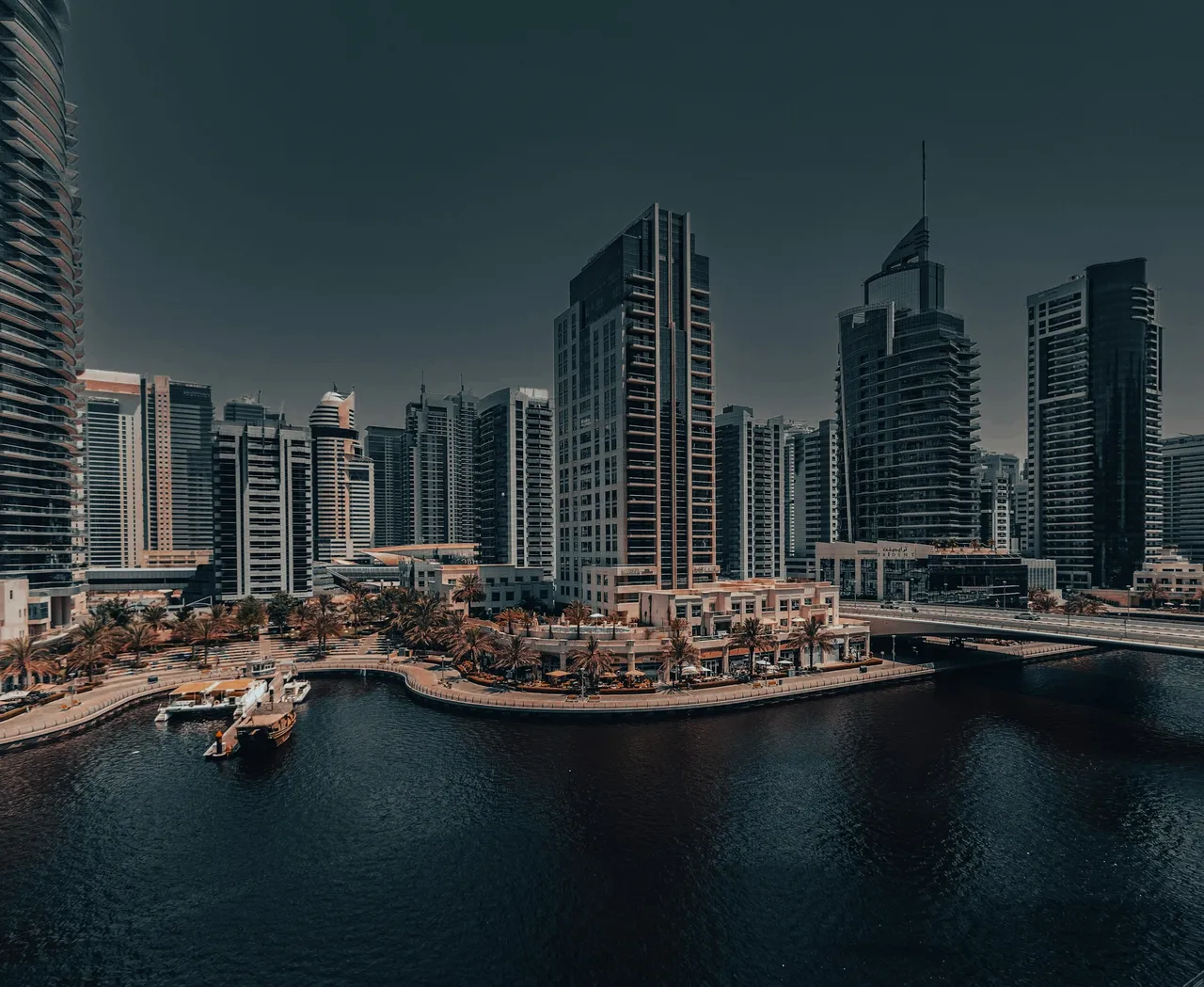 Dubai Marina waterfront and bridge beside completed residential towers. Area context, not a photograph of Beach Isle Tower 2.