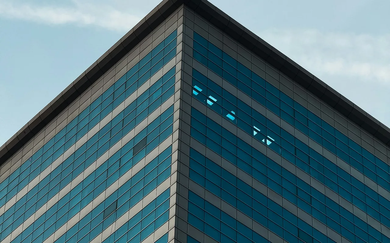 Glass building corner in Barsha Heights. Area context, not a photograph of Two Towers A.